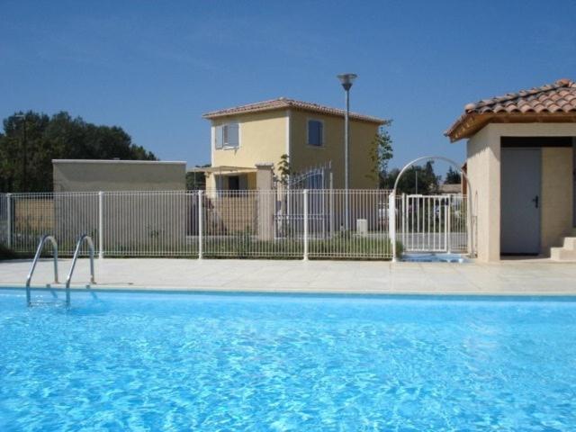 une piscine devant une maison dans l'établissement Villa tout confort, à 5mn de St Rémy de Provence, à Saint-Étienne-du-Grès