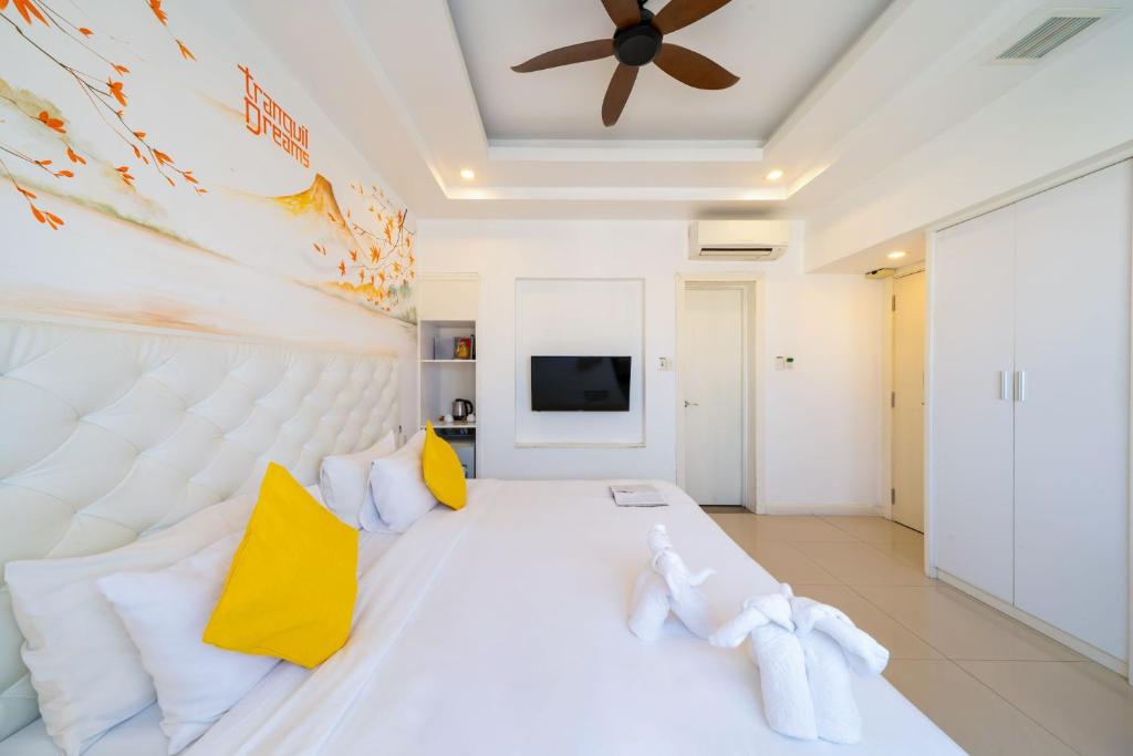 A close bedroom view showing the large bed, yellow accents, television and wardrobe.