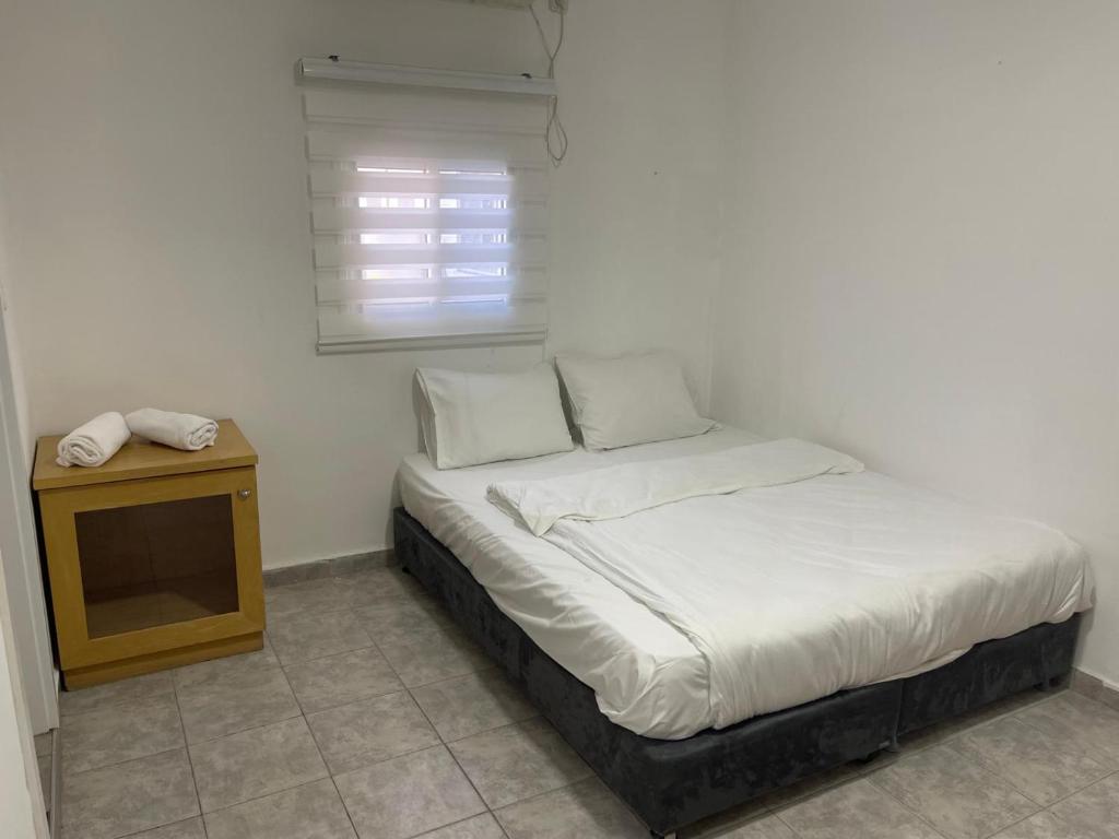 a bed in a room with a table and a window at Bella Vista House in Eilat