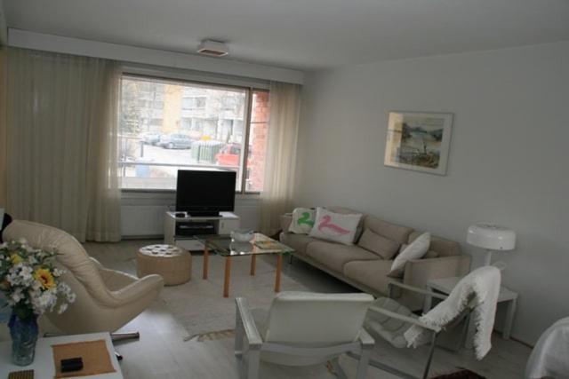a living room with a couch and chairs and a tv at Furnished flat in Naantali in Naantali