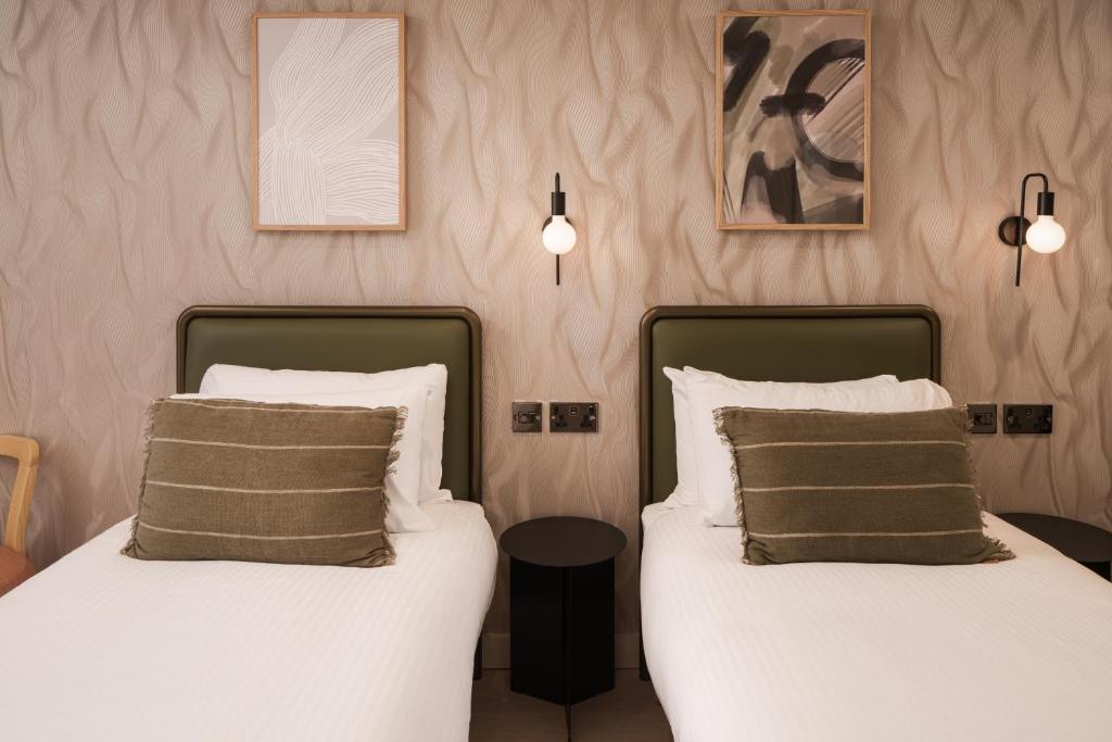 two beds sitting next to each other in a bedroom at Central Park Hotel in London