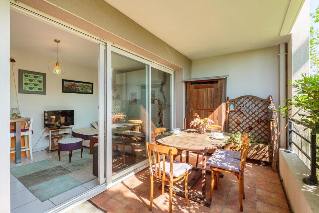 une terrasse avec une table et des chaises ainsi qu'une salle à manger dans l'établissement Appartement Pont Pierre - Welkeys, à Bayonne