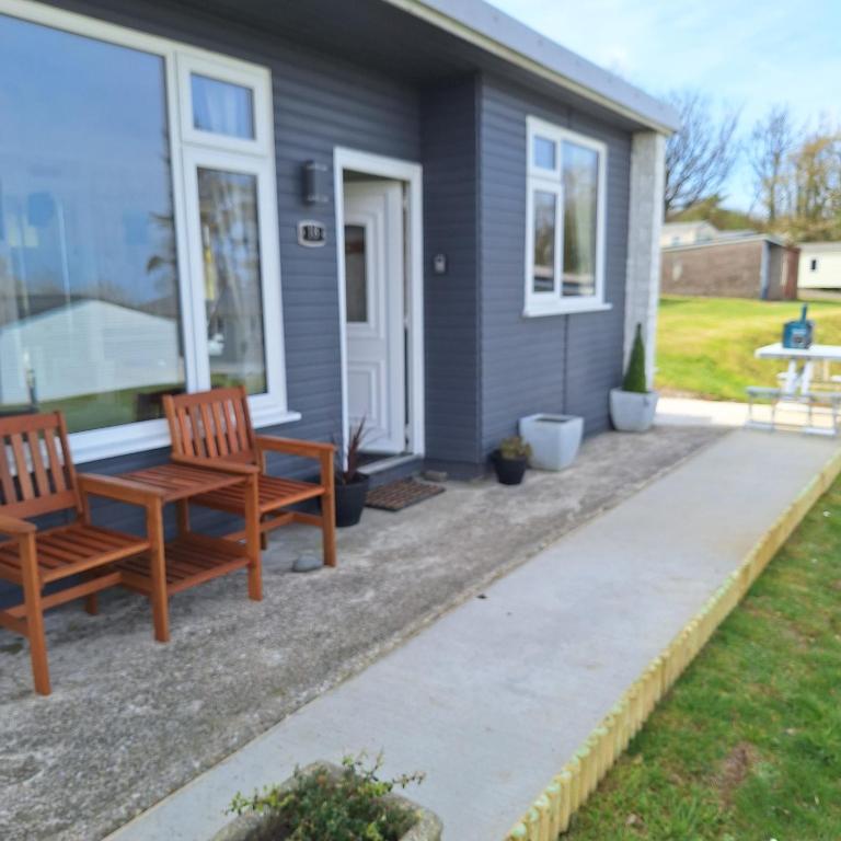 a patio with two chairs and a table in front of a house at 18 Sea Valley Bideford Bay Park Dean in Bideford