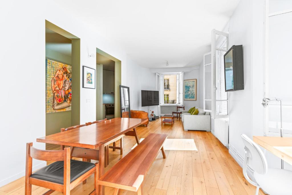 - une salle à manger et un salon avec une table en bois dans l'établissement Loft Flore, à Paris
