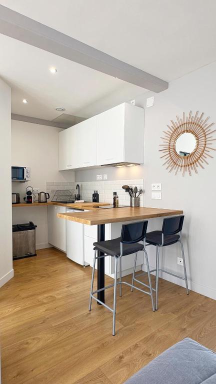 une cuisine avec une table en bois et deux chaises dans l'établissement Petit Malo, à La Rochelle