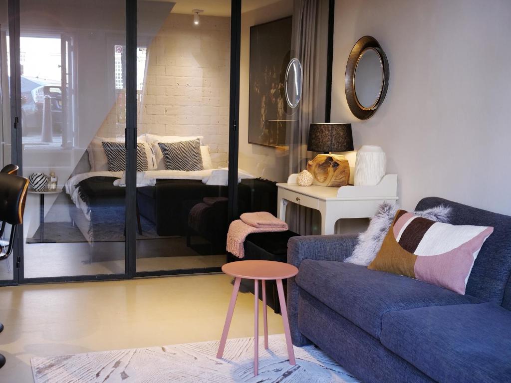a living room with a blue couch and a table at CANAL APARTMENT AMSTERDAM CENTRAL 4p in Amsterdam