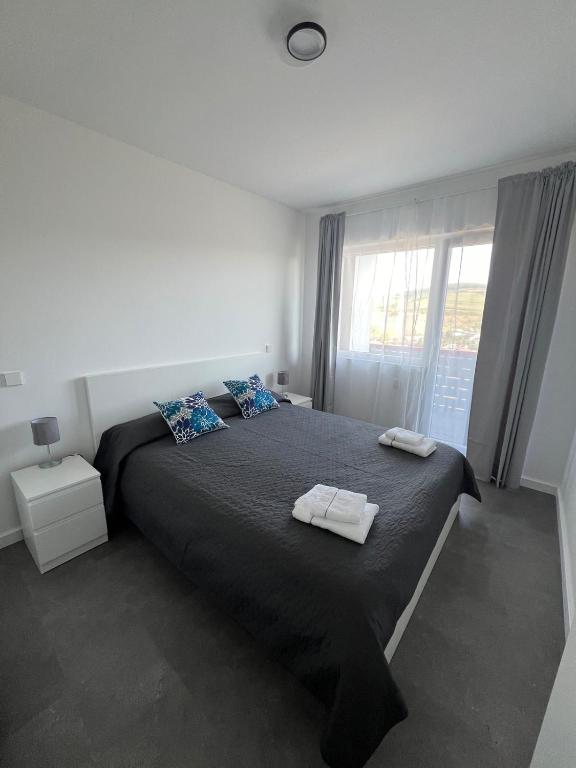 a bedroom with a large bed with two towels on it at Apartment Cluj, Baciu-Hills in Baciu