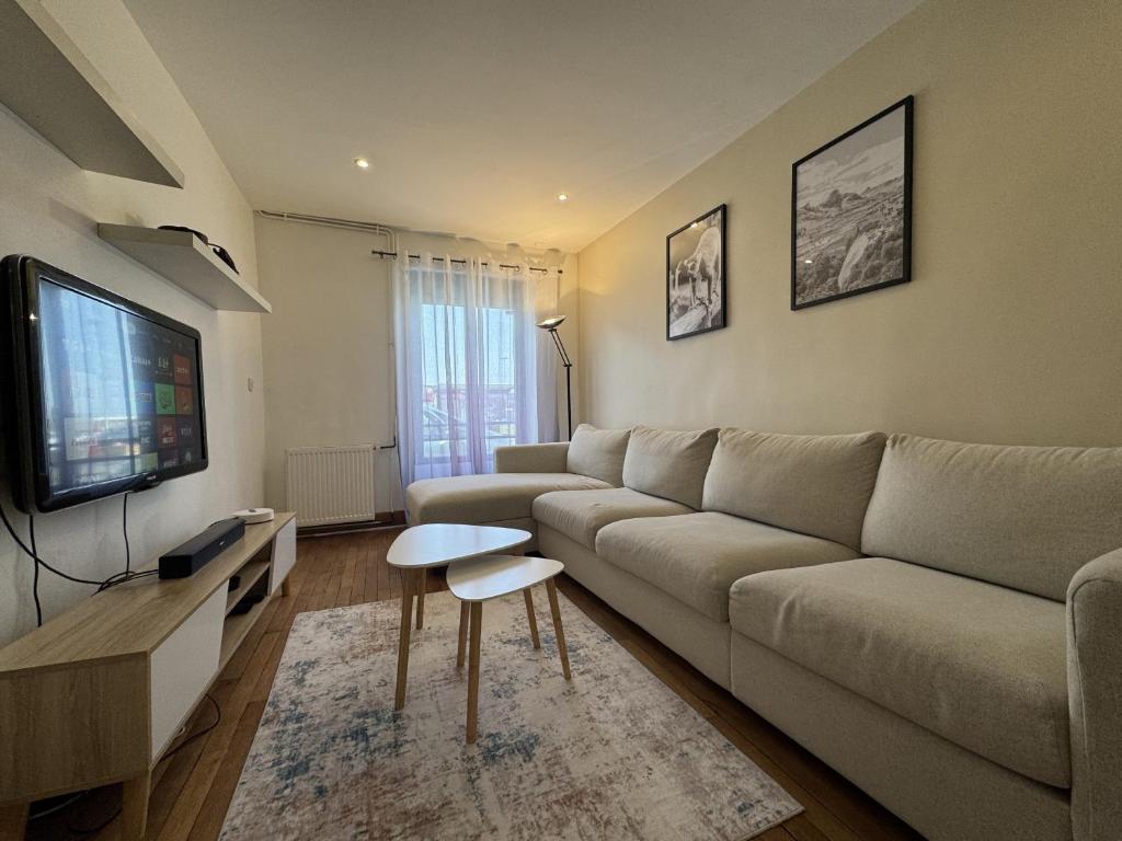 un salon avec un canapé et une télévision à écran plat dans l'établissement Le Maki - 10 pers - Rêve au Mans, au Mans