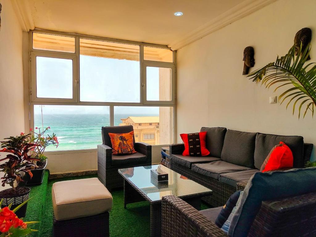 a living room with a couch and a view of the ocean at Vue ocean Almadies 300m2 3CH avec SDB Clim WiFi in Dakar