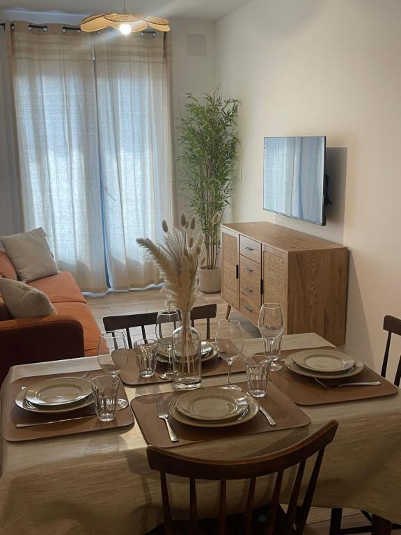 - une table à manger avec des assiettes et des verres à vin dans l'établissement Petite maison de village, à Bastelica