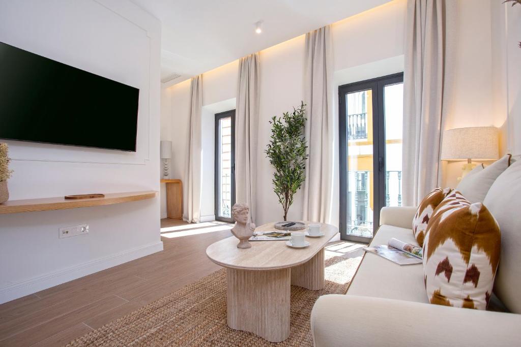 a living room with a tv and a couch and a table at Genteel Home Gamazo in Seville