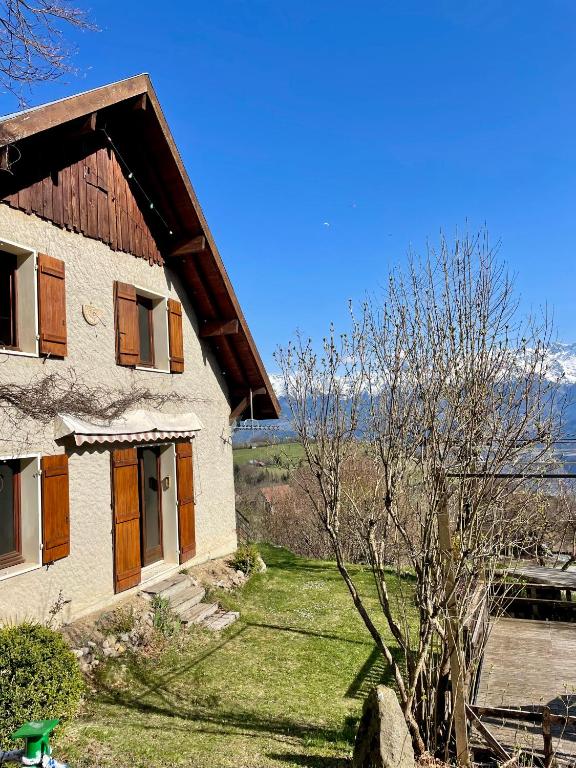une maison avec un arbre devant dans l'établissement Maison d'exception avec étang privé en chartreuse, à Saint-Pancrasse