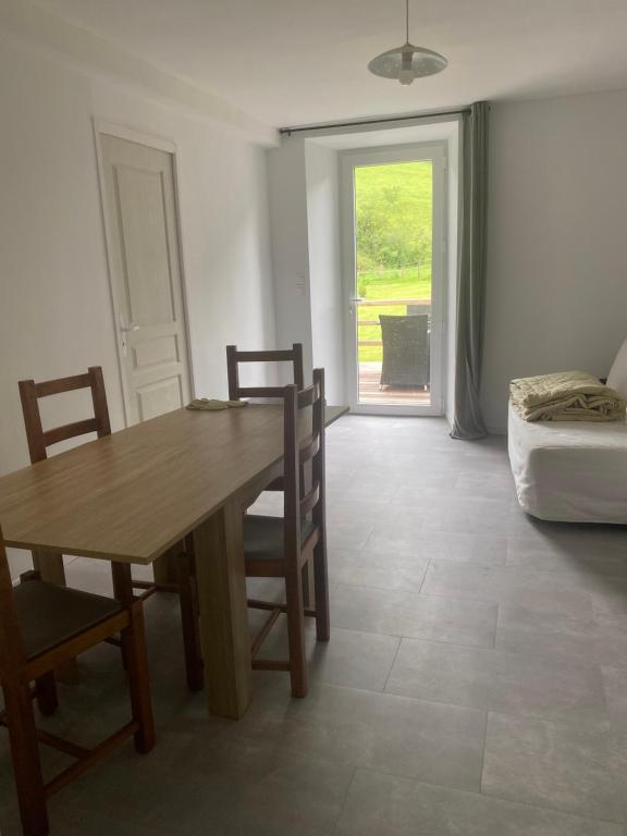 une salle à manger avec une table, des chaises et un canapé dans l'établissement Les orchidées, à Lurbe-Saint-Christau