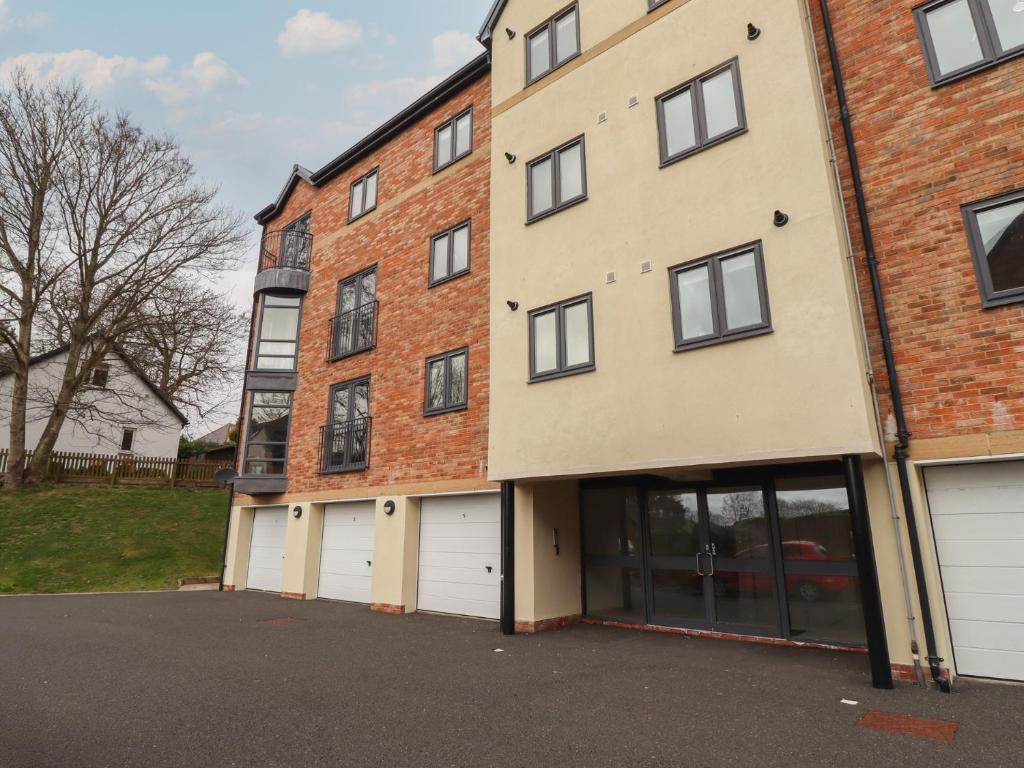 a large brick building with four garage doors at Assisi Apartment in Alnmouth