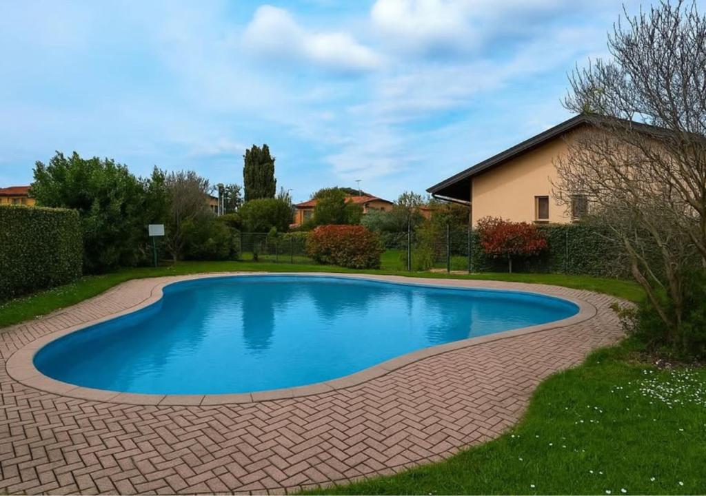 a swimming pool in a yard with a brick driveway at Casa Bacher Pool&GardenPrivate&2,5kilometri to Peschiera del Garda center in Peschiera del Garda