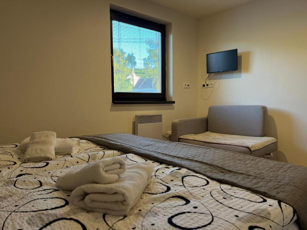 a bedroom with a bed with towels on it at Penzion u Studánky in Horní Věstonice