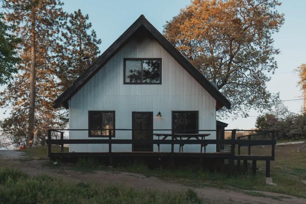 a large white building with a gambrel roof at Spacious 4-bedroom cabin on secluded private land in Miramonte