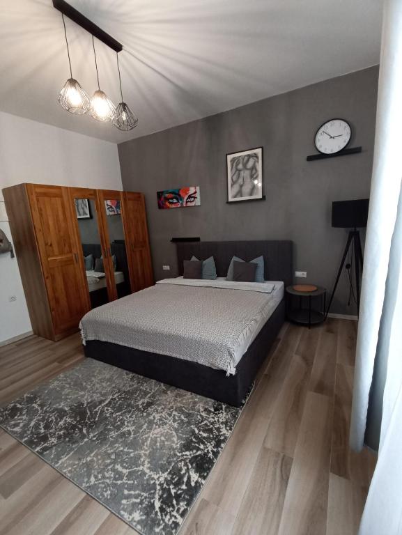 ein Schlafzimmer mit einem Bett und einer Uhr an der Wand in der Unterkunft Ted’s one in Ocna-Mureşului
