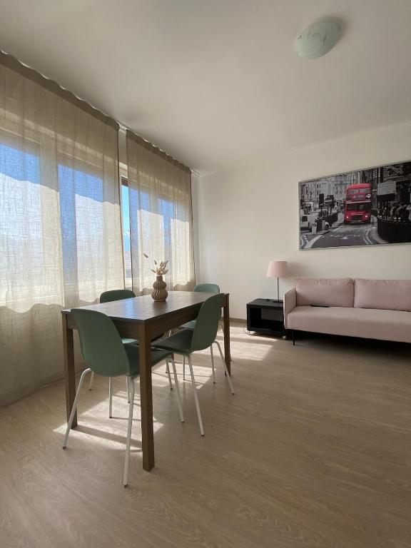 a living room with a table and chairs and a couch at Amalia-Levico Terme Apartment in Levico Terme