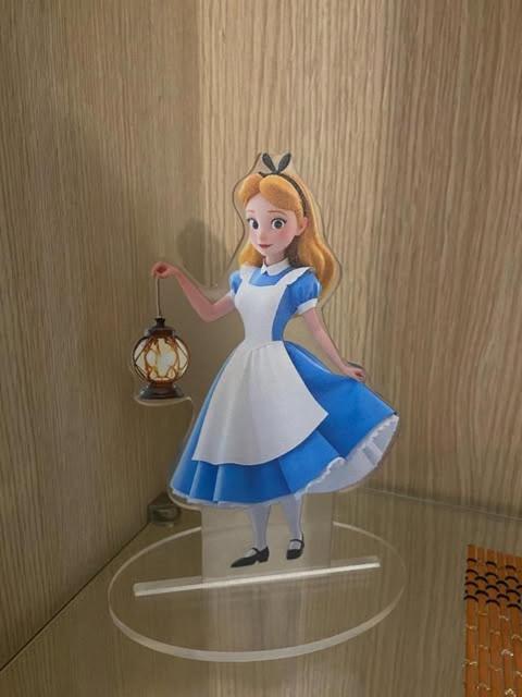 a toy girl in a dress is on a shelf at Alice's House in Civitavecchia