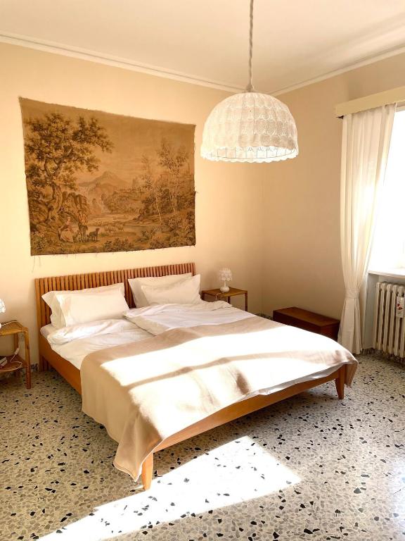 a bedroom with a large bed and a chandelier at Casa Borgo in Montasola