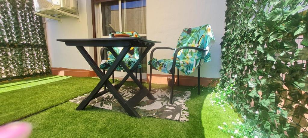 a black table and a chair in a yard at Apartamento Arena y Sal in Barbate