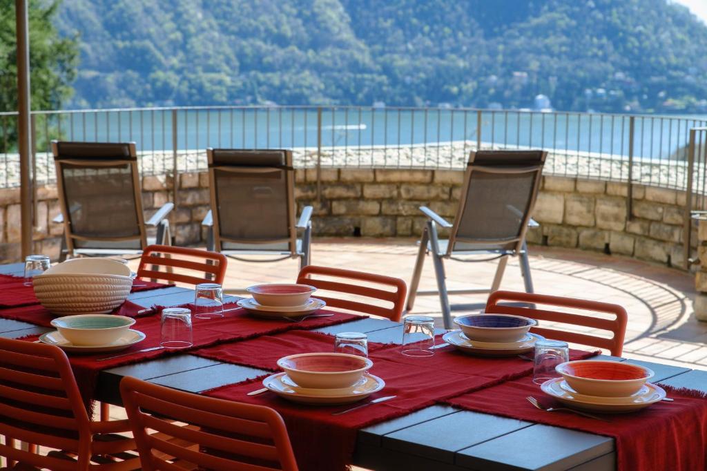 a table with bowls and plates on it with chairs at Crotto Polirolo by "The House Of Travelers" in Cernobbio
