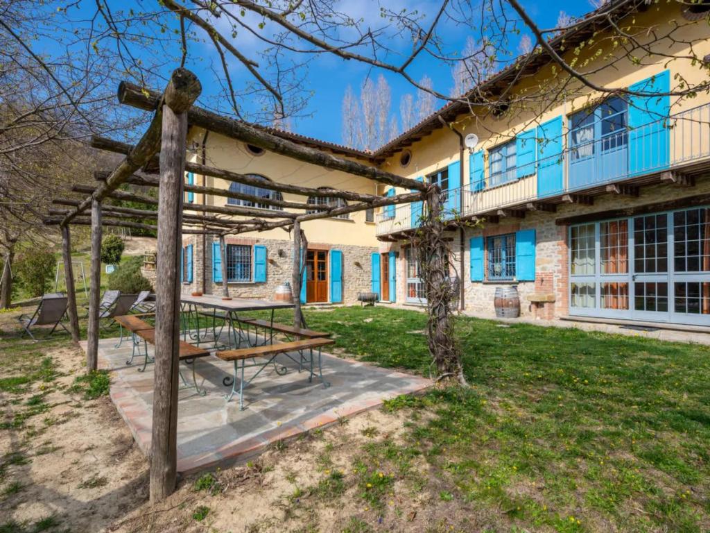 a house with a picnic table in the yard at Agriturismo La Rovere - Casale De Rovere in Cossano Belbo