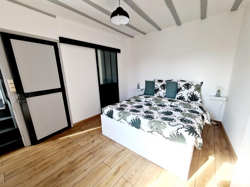 Un pat sau paturi într-o cameră la La Petite Maison Tourangelle