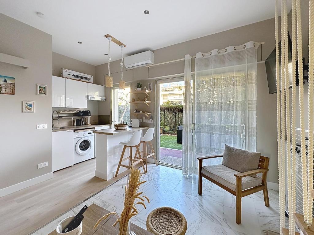 une cuisine avec un comptoir et une table avec une chaise dans l'établissement Cozy studio with garden and parking in Cannes, à Cannes