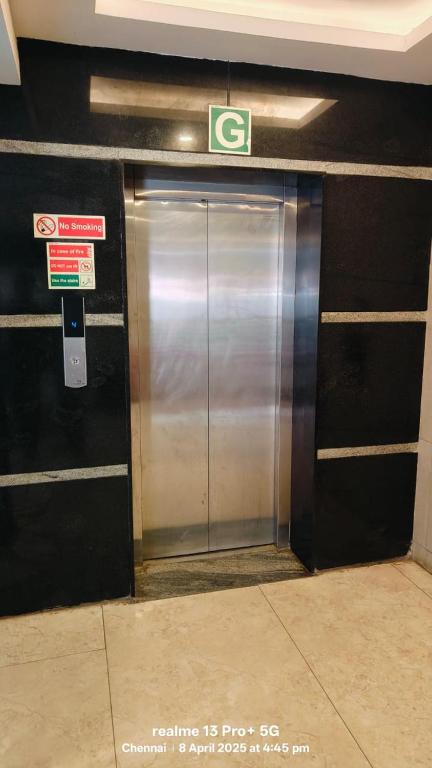 a metal elevator in a building with a sign on it at Hotel Starlight Chennai near DLF,L&T,Miot,Tradecenter,Ramachandra medical coll in Chennai