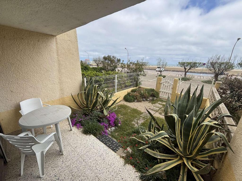 un patio avec une table, des chaises et des plantes dans l'établissement Appartement 2P 5 Couchages avec Terrasse et Parking - Port-la-Nouvelle - FR-1-229C-159, à Port-la-Nouvelle