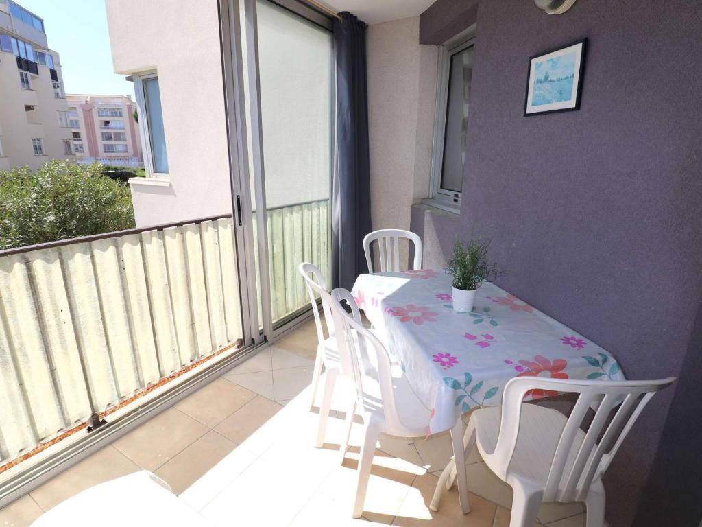 un balcon avec une table et des chaises sur un balcon dans l'établissement Appartement 2 Pièces, 4 Couchages, Parking Privatif, à 100m de la Mer et des Commerces - FR-1-307-48, au Grau-du-Roi