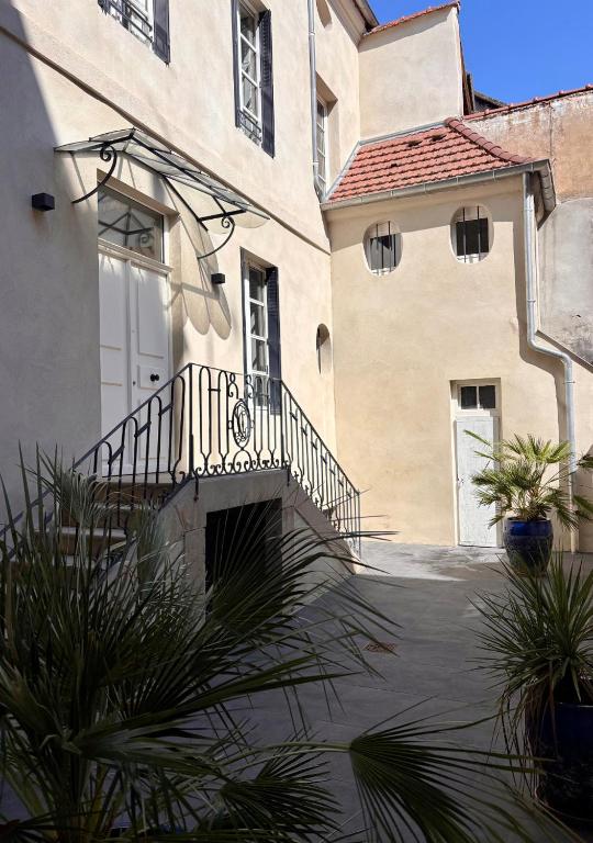 a large building with a staircase next to a house at L'Hotel Particulier in Louhans