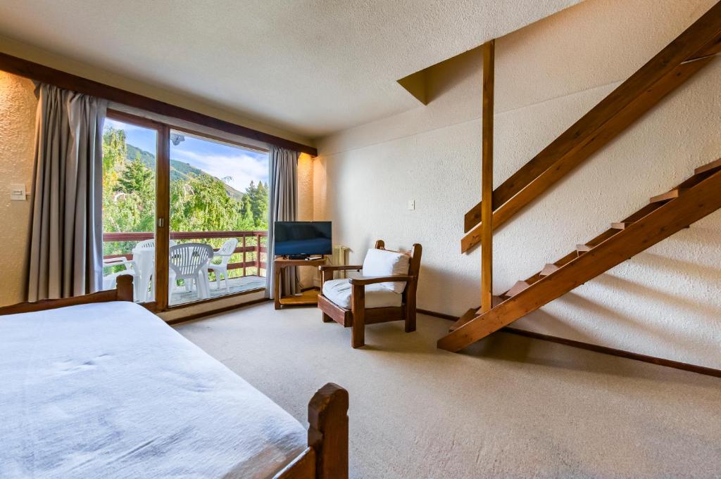 a bedroom with a bed and a large window at Apartur Catedral in San Carlos de Bariloche