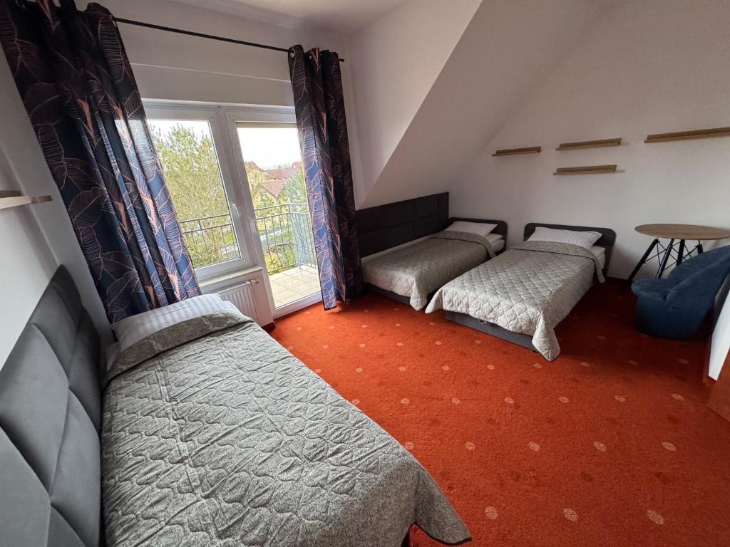 a bedroom with two beds and a window at Tasarz 2 in Rewal
