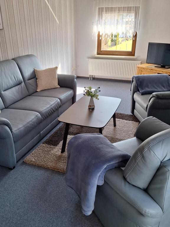 a living room with two couches and a coffee table at Kapitänskoje in Breege