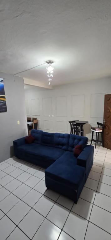 a living room with a blue couch and a table at Casa na Praia de Iracema R&S in Fortaleza