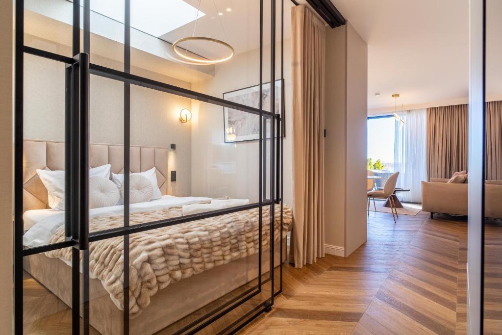 a glass room with a bed and a living room at P R A T U M Pink&Blue Mikołajki Apartament Elegance z widokiem na jezioro in Mikołajki