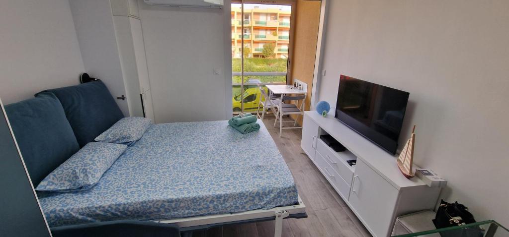 une petite chambre avec un lit et une télévision dans l'établissement joli studio refait a neuf, à Bormes-les-Mimosas