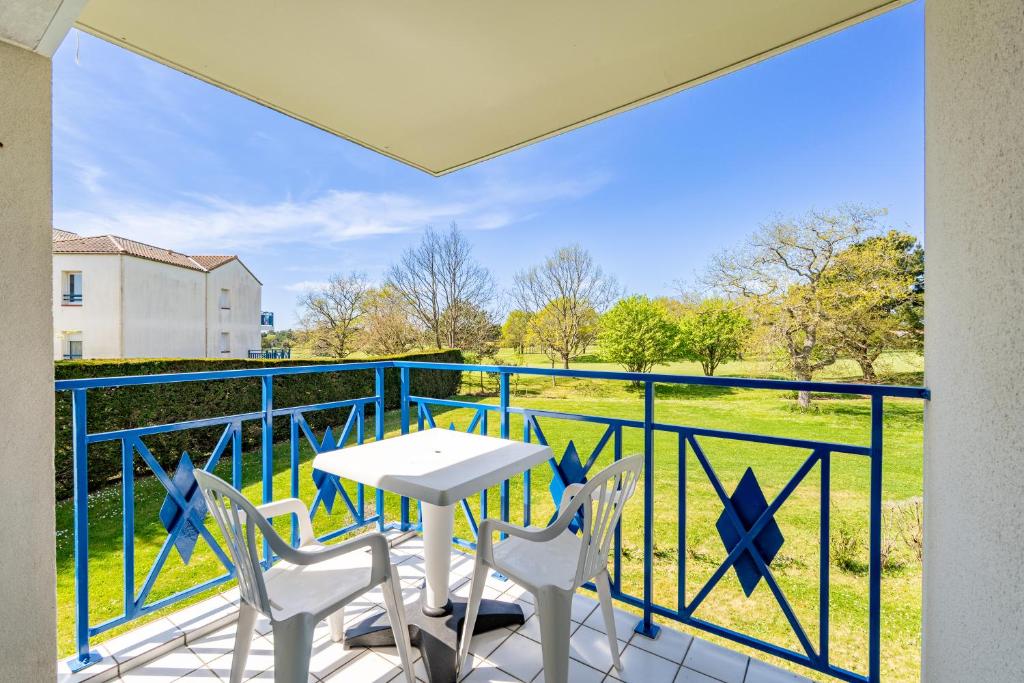 eine Terrasse mit Tisch und Stühlen auf einem Balkon in der Unterkunft 07 - Villa Sainte Marie, Vue golf in Pornic