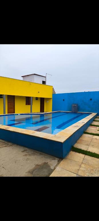 un edificio giallo e blu con una piscina di Casa praia peito de moca a Luis Correia