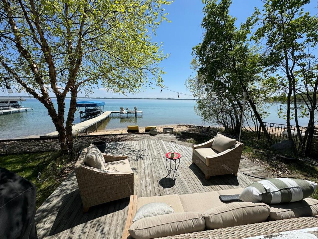 a patio with two couches and a view of the water at Lakefront Bliss on Old Mission Peninsula in Traverse City