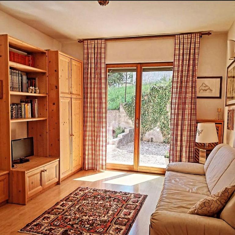 un soggiorno con un divano e una grande finestra di Pupili's a Calalzo