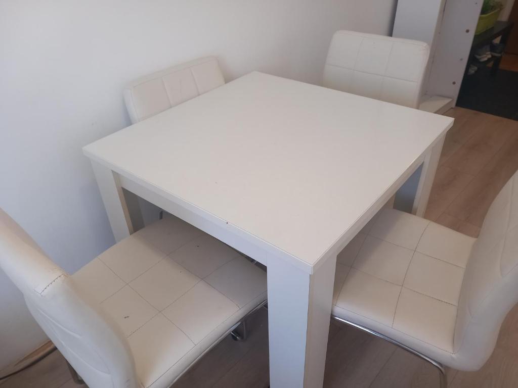 a white table and two white chairs in a room at Djordje in Belgrade