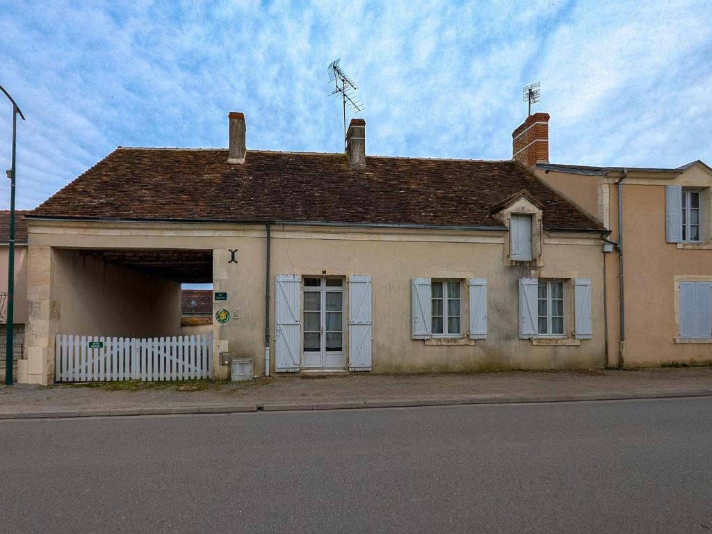 an old building with a garage with a windmill on top at Maison de plain-pied en Brenne avec cour close, Wifi et proche de Châteauroux et étang de pêche - FR-1-591-104 in Neuillay-les-Bois