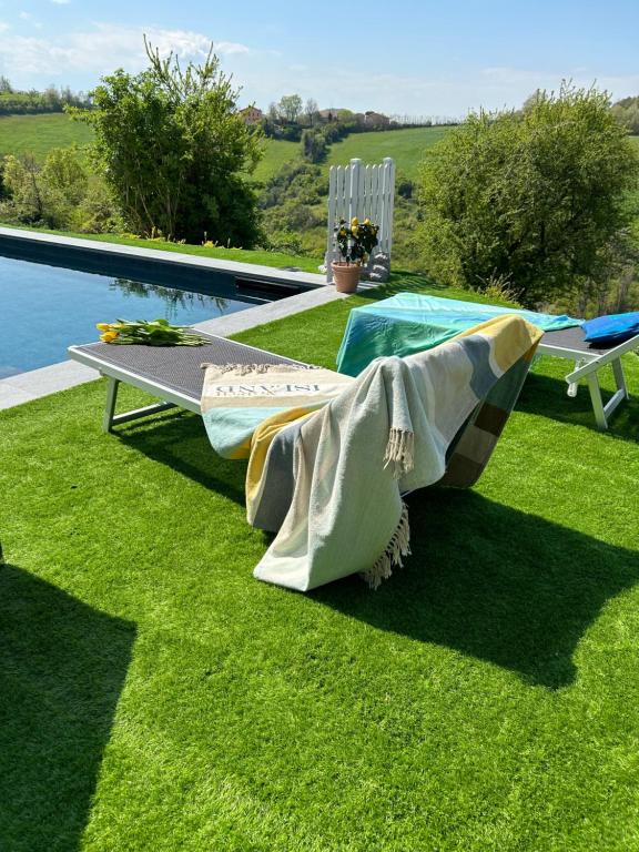 a bench on the grass next to a pool at Casa Sunset Hill Bologna in Bologna