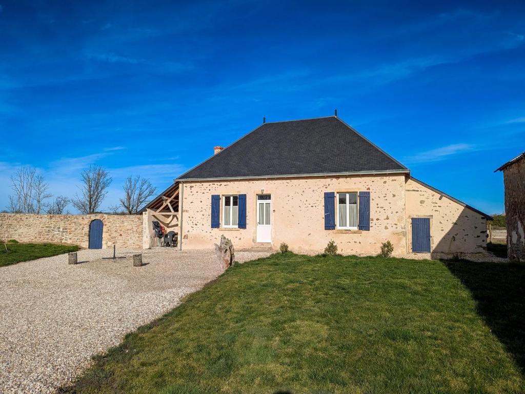 una casa in mattoni con tetto nero e cortile di Gîte au cœur du Parc de la Brenne avec jardin, terrasse et parking - FR-1-591-317 a Migné