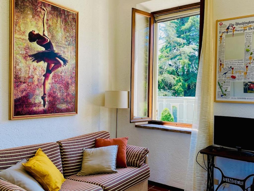 ein Wohnzimmer mit einem Sofa und einem Bild einer Tänzerin in der Unterkunft La finestra sul parco Croara Country Club in Pieve Dugliara