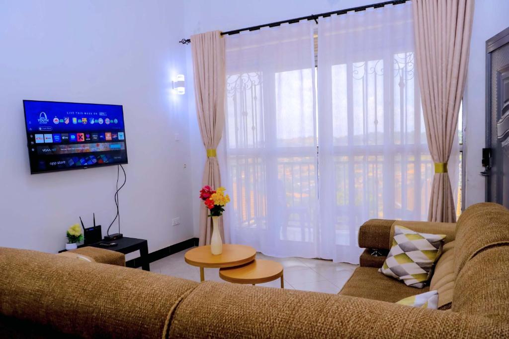 a living room with a couch and a flat screen tv at Kampala Hilltop Haven 2 Bedroom Gem in Kampala